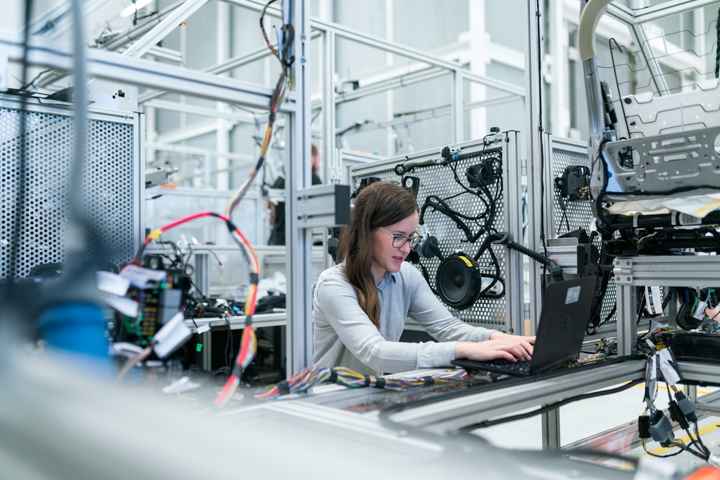 Woman working on laptop with technology and automation interface in background