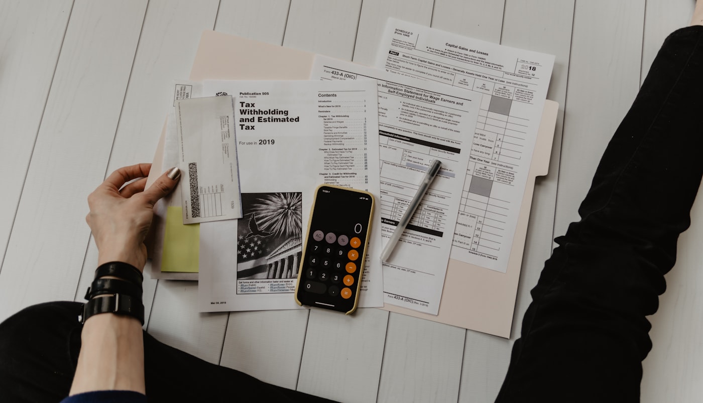 Calculator and notepad with financial planning notes on a desk