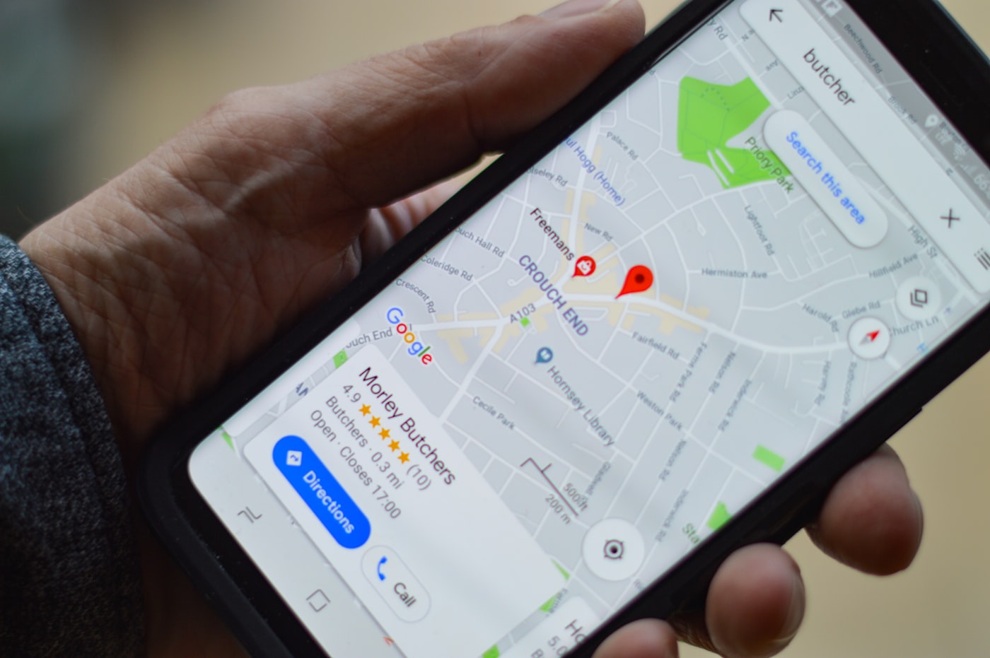Person holding smartphone showing map results for local businesses