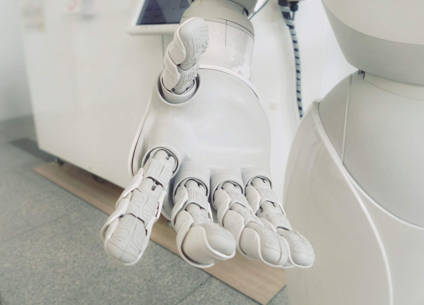 A white robotic hand, the human-machine interface at the heart of AI