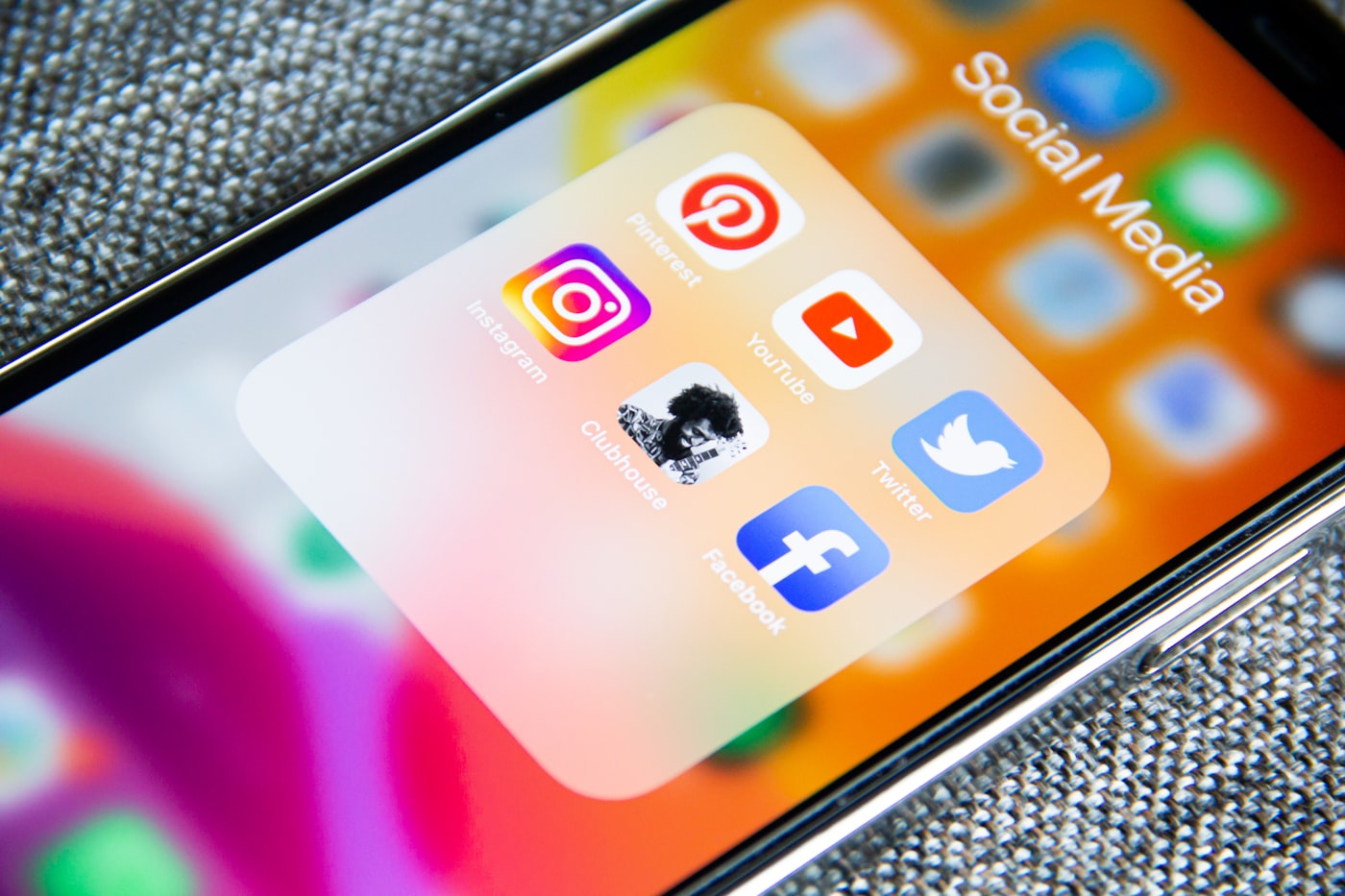 Person creating social media content on a smartphone and laptop